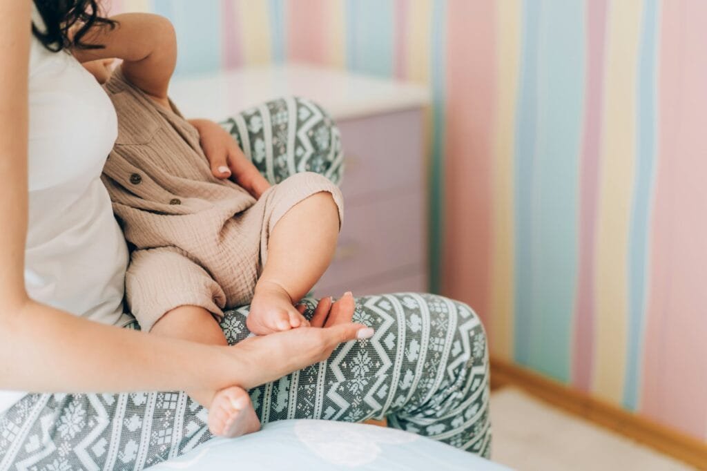 Young mother is breastfeeding her baby. In Vitro Fertilization IVF . Family of asians